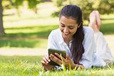 Woman text messaging while relaxing in park