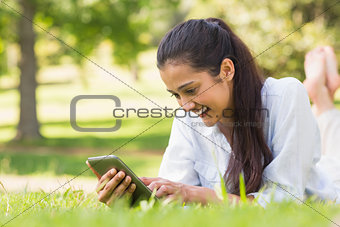 Woman text messaging while relaxing in park