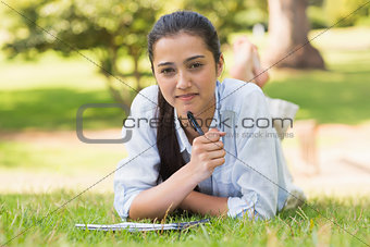Portrait of a woman with book and pen in park