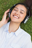 Cheerful young woman enjoying music in park