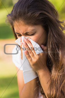 Woman blowing nose with tissue paper