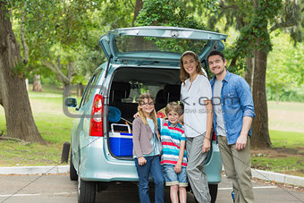 Family of four by car trunk while on picnic