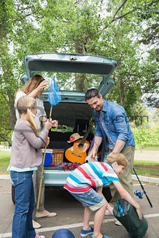 Family unloading car trunk while on picnic