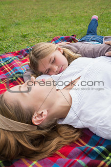 Relaxed mother and daughter lying at park