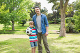 Portrait of father and son with ball at park