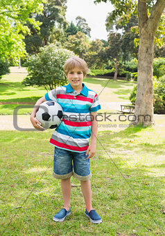 Full length portrait of a boy with ball at park