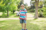 Portrait of a smiling boy with ball at park