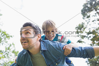 Father carrying cheerful boy on back