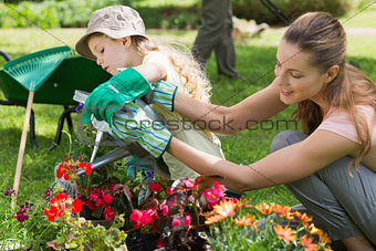 Mother and daughter watering plants at garden