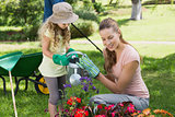 Mother with daughter watering plants