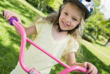 Little girl on a bicycle at summer park