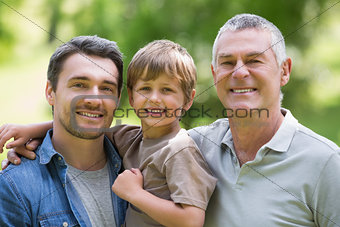 Grandfather father and son smiling at park