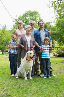 Happy extended family with pet dog at park
