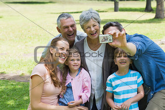 Man taking picture of extended family at park