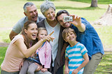Man taking picture of extended family at park