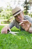 Man cutting grass with scissors