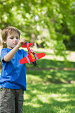 Cute boy with toy aeroplane at park