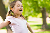 Girl with arms outstretched and eyes closed at park