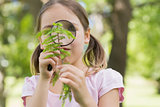 Girl examining leaves with magnifying glass at park