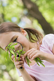 Girl examining leaves with magnifying glass at park