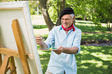 Mature man painting in park