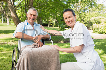 Woman with her father sitting in wheel chair at park