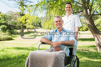 Woman with her father sitting in wheel chair at park