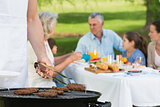 Barbecue grill with extended family having lunch in park