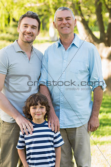 Grandfather father and son smiling at park
