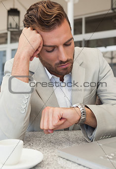 Frowning businessman looking at his watch