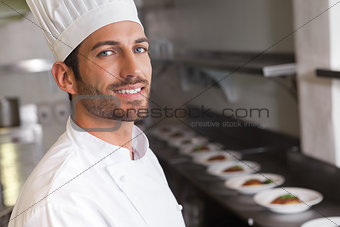 Cheerful young chef smiling at camera