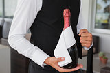 Well dressed waiter holding magnum of champagne