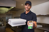 Cheerful pizza delivery man holding credit card machine