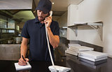 Handsome pizza delivery man taking an order over the phone