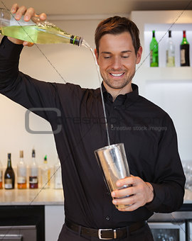 Happy bartender preparing a cocktail