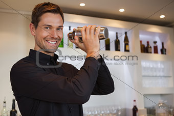 Smiling bartender shaking cocktail