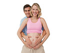 Expectant smiling parents holding mothers baby bump