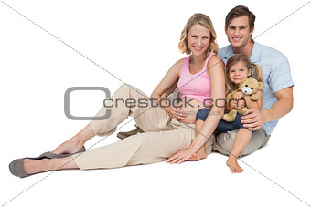 Happy young family expecting a new arrival smiling at camera