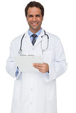 Handsome doctor smiling at camera holding clipboard