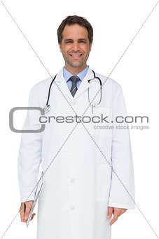 Happy doctor smiling at camera holding clipboard
