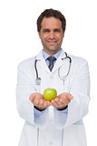Smiling doctor showing apple to camera