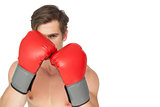 Tough man wearing red boxing gloves in guard position
