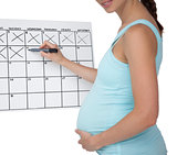 Pregnant woman marking off dates on the calendar
