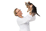 Vet holding up yorkshire terrier puppy and smiling
