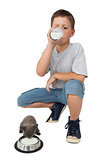 Cute little boy and grey kitten both drinking milk