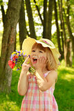 beautiful little girl in nature with a bouquet of flowers 