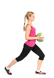 Girl doing lunges exercise with medicine ball 