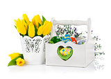 Easter eggs in basket with spring flowers