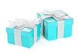 Two blue gift boxes with silver ribbon and bow