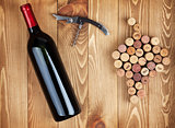 Red wine bottle, corkscrew and grape shaped corks